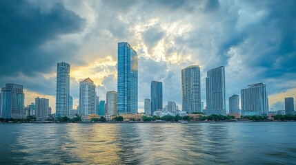 Naklejka premium Skyline of modern Bangkok, Thailand. Majestic skyscrapers on the waterfront under the cloudy sky at twilight time.