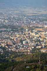 Dramatic cityscape panorama overlooking green hills