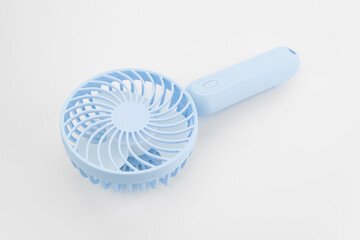 Mini electric pink fan with handle, isolated on white background. Portable electrical equipment that very useful when hot weather	
