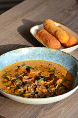 close up view of food served in restaurant on wooden table, mushroom goulash or ragout with fried...