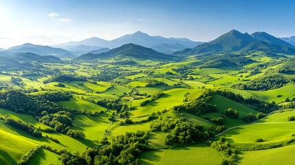 A beautiful green landscape with mountains in the background. The sky is clear and the sun is shining brightly. Concept of peace and tranquility, as the vast open fields and mountains create a serene