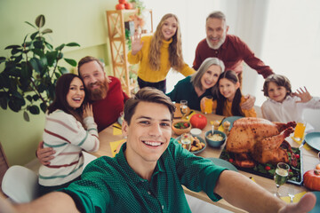 Photo of beautiful joyful happy people enjoying time together taking selfie indoors room home