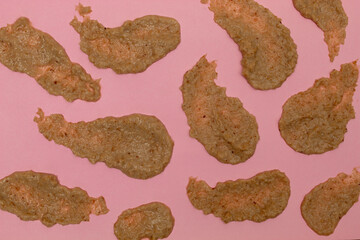 Texture of walnut and cinnamon cream on pink background