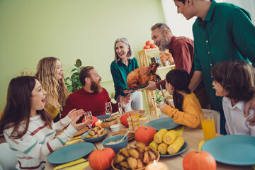 Photo of charming happy family spouses showing table roasted turkey celebrating thanksgiving day indoors