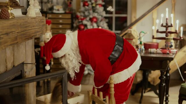 Man Wearing Santa Suit Making Wood Fire In The Fireplace