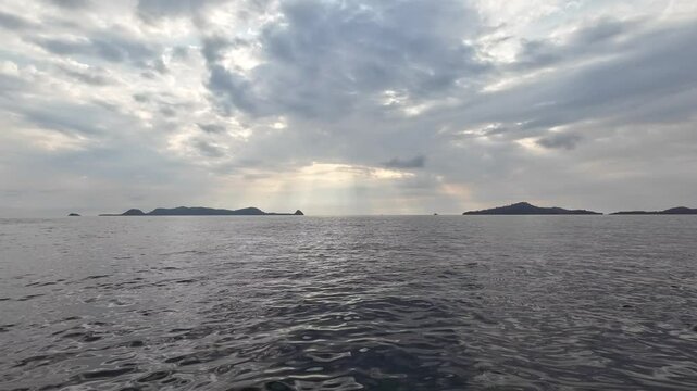 Ray of light in the afternoon before sunset. Between islands. Dark cloudy sky. The footage was taken in the midle of the sea. Mandeh, West Sumatra, Indonesia