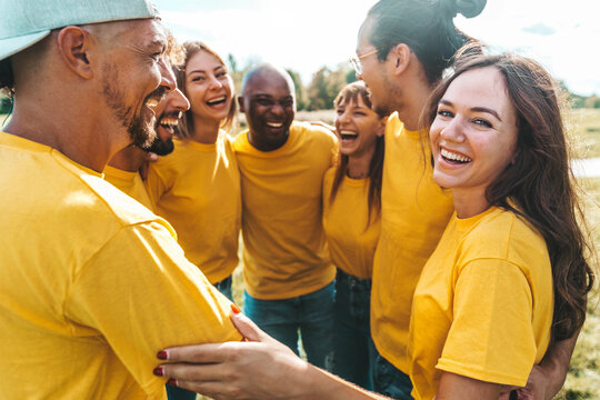 Multiracial group of people hugging outdoors - Happy friends having fun hanging outside - Youth community concept with guys and girls supporting each other
