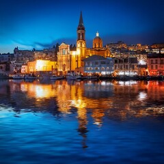 Fototapeta premium Shimmering Nights: Church and City Lights Reflecting on the Sea