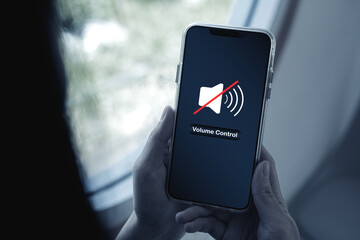 Close-up view of Hand pressing volume of smartphone in silent or mute mode activated.