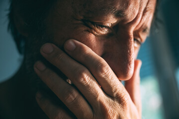 Fototapeta premium Emotional distraught sad man crying stressed, dealing with mental health problems, depression, anxiety and despair