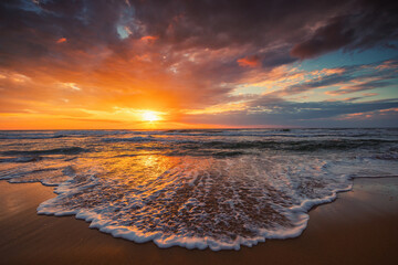 Beautiful cloudscape over the sea shore during scenic dramatic sunrise