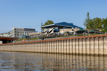 Low water levels of river IJssel with town jetty quay rising up high mirroring in the waterway with...