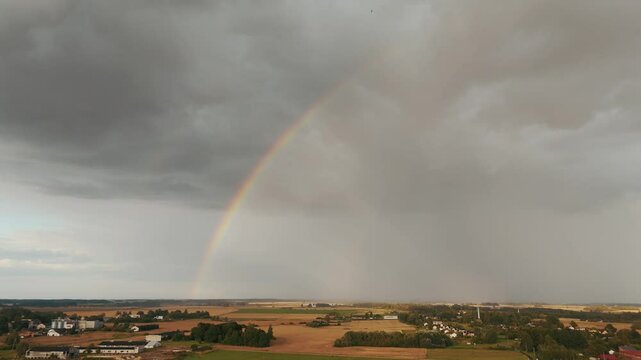 The Rainbow Over the Green Field After Storm With Rain, During Outumn, Aerial View Under Heavy Clouds Before Thunderstorm. Agriculture Landscape Many Crop Fields. Aerial 4k Shot