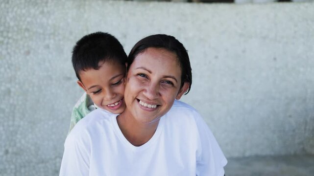 Latin son child hugging mom, celebrating international mother's day. Family love relationship
