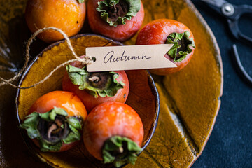 Persimmons elegantly displayed in an autumn-themed arrangement