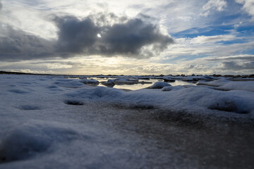 Snow cloud above icy Baltic sea.
