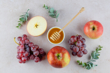 Autumn harvest, thanksgiving day concept. Fresh apples and grapes arranged with honey on a light countertop for a healthy snack preparation. space for text. top view