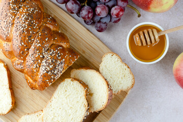 Homemade challah with honey, grapes, apples on a light background. Traditional Jewish sabbath Challah bread. Concept of Jewish holiday and festive baking. space for text. top view