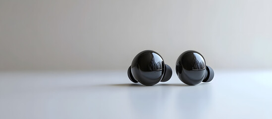 Modern wireless earbuds in a sleek black design displayed on a white background in a high resolution copy space image