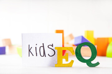 Kids EQ, child emotional quotient concept with wooden cubes children toys on background, wooden cubes kids toys on background, letters text lettering EQ in the foreground