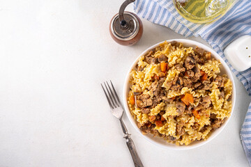 Easy homemade pasta with minced meat. One pot pasta with ground beef and autumn vegetables, in portioned plate on kitchen table