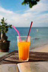 Fresh fruit cocktails on tropical island with sea view background and smoothed menu on the foreground.