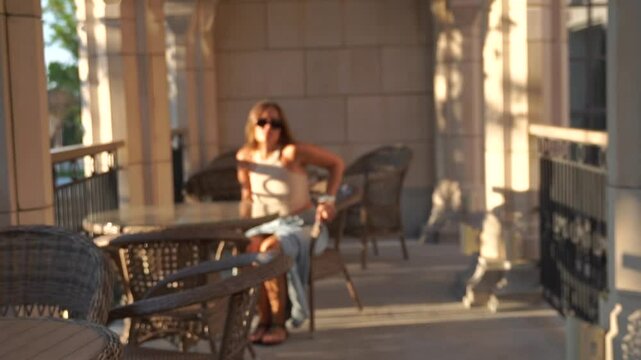 Woman Porch Sunlight Relaxing - Woman sitting on porch in sunlight, relaxing on wooden chairs.