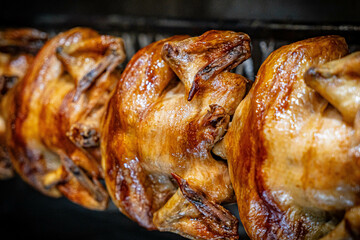 Barbecue roast Chicken in a row turning at industrial roaster grill