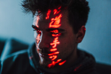 close-up portrait of a male person in a cyberpunk environment with red lights in his face