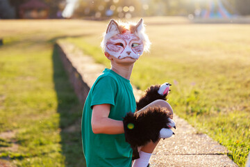 Confident young little kid boy wear cat furry mask enjoy have fun playing outdoors in forest street park. Children therian wild animal character trendy fan culture. Teenager social expression hobby