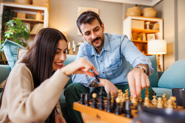 Couple enjoying leisure time at home playing chess