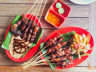 two kinds of goat satay dishes on the table, goat satay with peanut sauce and goat satay with tomato sambal