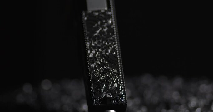 Detail Of A Laser Engraved Handgun With A Black Backdrop. Close-up Shot