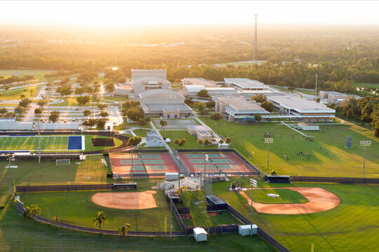 Aerial view of high school open air sports facilities in Florida. American football stadium, tennis court and baseball diamond sport infrastructure.
