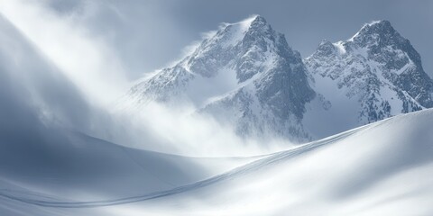 Fototapeta premium Majestic snow-covered mountains shrouded in mist, capturing the serene beauty of a winter landscape with dramatic peaks and soft snow.