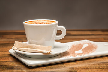 Hot Milk Tea, Chai, Espresso or Cappuccino Coffee with Sugar and Cinnamon served in white cup isolated on wooden table side view of hot drink
