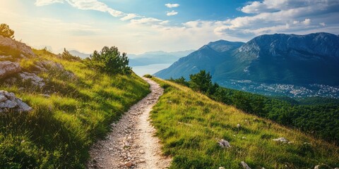 A serene path leads through lush grass and mountains, inviting nature lovers to explore the tranquil landscape.