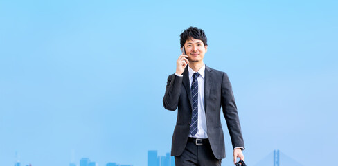 スマホで話しながら歩く男性ビジネスマン