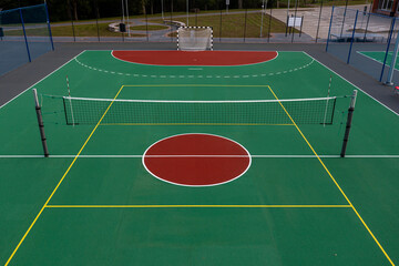 Multi-sport court featuring volleyball and handball setup during bright daylight
