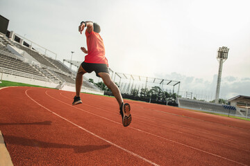 The runer runs on a red rubber running track, starting off using the starting block....