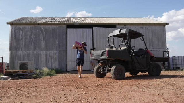 Loading farm supply on ATV quad bike transportation in rural Australia