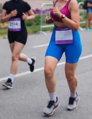 Marathon runners crowd, sportsmen participants start running the half-marathon in the city streets, crowd of sportswomen joggers in motion, group athletes outdoor training competition in a summer day