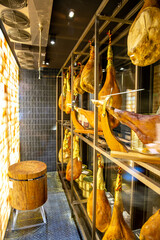 Dry-cured pork ham, jamon, hanging on hooks in the refrigerator