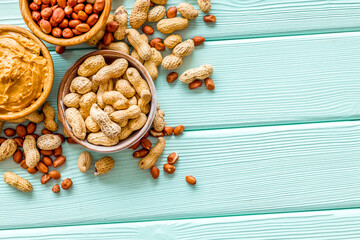 Product for hearty breakfast with peanut butter in bowl near nut