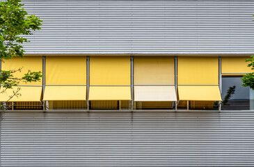 Sonnenschutz durch gelbe Markisen an einem Bürogebäude