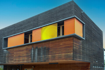 Modernes Gebäude mit einer teilweisen Holzfassader und farbigen Fenstern
