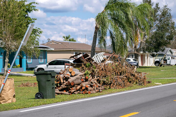 Heaps of limbs and branches debris from hurricane winds on street side waiting for recovery truck...