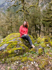 young girl against the background of snowdrops in the forest in spring