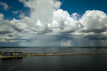 Fototapeta premium Heavy thunderstorm approaching traffic bridge connecting Punta Gorda and Port Charlotte over Peace River. Bad weather conditions for driving during rainy season in Florida