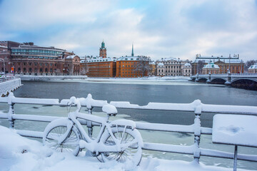 Snowy bike in front of government buildings a gray and snowy winter day in Stockholm